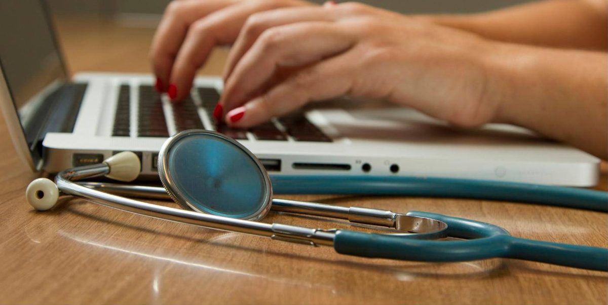 Consulta médica online con estetoscopio junto al ordenador